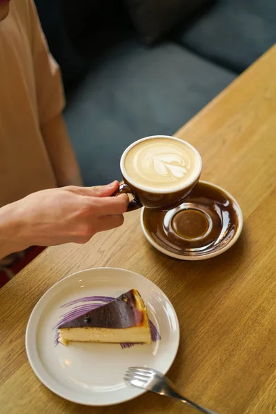 guy holding a cup of coffee in a coffee shop