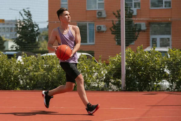 小伙子在篮球场上打篮球 把球丢进圈子里 做运动 健康的身体和健康的生活方式 — 图库照片