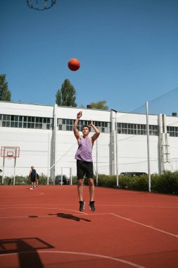Genç adam basketbol sahasında basketbol oynuyor. Topu ringe fırlattı. Spor yapıyorum. sağlıklı vücut ve sağlıklı yaşam tarzı