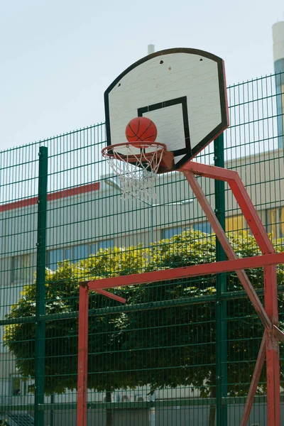 Genç adam basketbol sahasında basketbol oynuyor. Topu ringe fırlattı. Spor yapıyorum. sağlıklı vücut ve sağlıklı yaşam tarzı