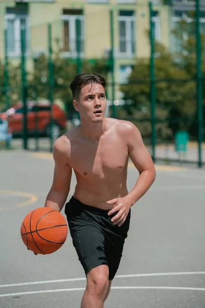 小伙子在篮球场上打篮球 把球丢进圈子里 做运动 健康的身体和健康的生活方式 — 图库照片