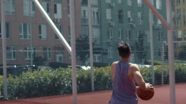 Genç adam basketbol sahasında basketbol oynuyor. Topu ringe fırlattı. Spor yapıyorum. sağlıklı vücut ve sağlıklı yaşam tarzı