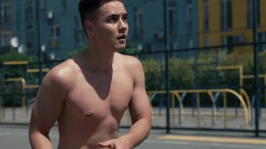 Genç adam basketbol sahasında basketbol oynuyor. Topu ringe fırlattı. Spor yapıyorum. sağlıklı vücut ve sağlıklı yaşam tarzı