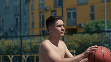 Genç adam basketbol sahasında basketbol oynuyor. Topu ringe fırlattı. Spor yapıyorum. sağlıklı vücut ve sağlıklı yaşam tarzı