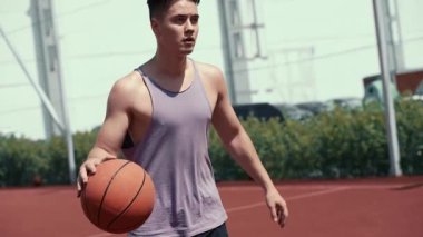 Genç adam basketbol sahasında basketbol oynuyor. Topu ringe fırlattı. Spor yapıyorum. sağlıklı vücut ve sağlıklı yaşam tarzı