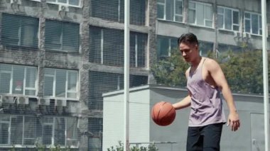 Genç adam basketbol sahasında basketbol oynuyor. Topu ringe fırlattı. Spor yapıyorum. sağlıklı vücut ve sağlıklı yaşam tarzı