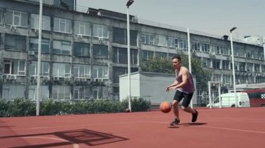 Genç adam basketbol sahasında basketbol oynuyor. Topu ringe fırlattı. Spor yapıyorum. sağlıklı vücut ve sağlıklı yaşam tarzı