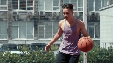 Genç adam basketbol sahasında basketbol oynuyor. Topu ringe fırlattı. Spor yapıyorum. sağlıklı vücut ve sağlıklı yaşam tarzı