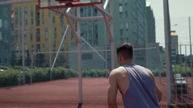 Genç adam basketbol sahasında basketbol oynuyor. Topu ringe fırlattı. Spor yapıyorum. sağlıklı vücut ve sağlıklı yaşam tarzı