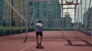 Genç adam basketbol sahasında basketbol oynuyor. Topu ringe fırlattı. Spor yapıyorum. sağlıklı vücut ve sağlıklı yaşam tarzı