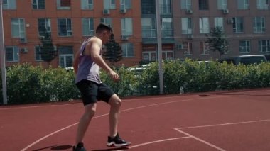 Genç adam basketbol sahasında basketbol oynuyor. Topu ringe fırlattı. Spor yapıyorum. sağlıklı vücut ve sağlıklı yaşam tarzı