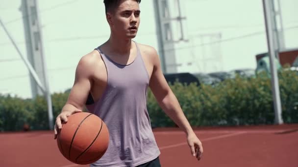 小伙子在篮球场上打篮球 把球丢进圈子里 做运动 健康的身体和健康的生活方式 — 图库视频影像