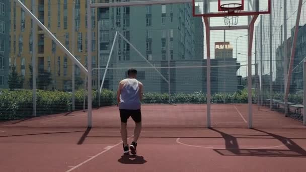 Junger Kerl Spielt Basketball Auf Dem Basketballplatz Wirft Den Ball — Stockvideo