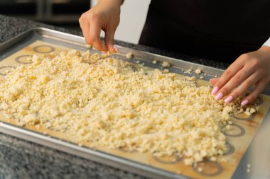 Genç aşçı kız tatlı yapıyor. Tatlı ve kek pişirir. Boşlukları doldurur ve meyveleri hazırlar. Pişirme, tatlı, tatlılar, karmaşık pişirme süreçleri.