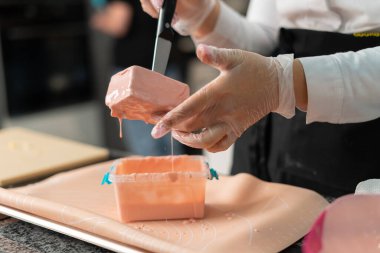 Genç aşçı kız tatlı yapıyor. Tatlı ve kek pişirir. Boşlukları doldurur ve meyveleri hazırlar. Pişirme, tatlı, tatlılar, karmaşık pişirme süreçleri.