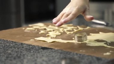 Genç aşçı kız tatlı yapıyor. Tatlı ve kek pişirir. Boşlukları doldurur ve meyveleri hazırlar. Pişirme, tatlı, tatlılar, karmaşık pişirme süreçleri.