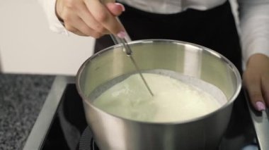 Genç aşçı kız tatlı yapıyor. Tatlı ve kek pişirir. Boşlukları doldurur ve meyveleri hazırlar. Pişirme, tatlı, tatlılar, karmaşık pişirme süreçleri.