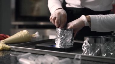 Genç aşçı kız tatlı yapıyor. Tatlı ve kek pişirir. Boşlukları doldurur ve meyveleri hazırlar. Pişirme, tatlı, tatlılar, karmaşık pişirme süreçleri.
