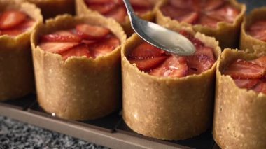 Genç aşçı kız tatlı yapıyor. Tatlı ve kek pişirir. Boşlukları doldurur ve meyveleri hazırlar. Pişirme, tatlı, tatlılar, karmaşık pişirme süreçleri.