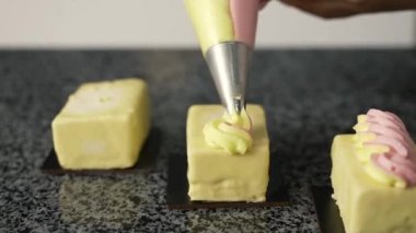 Genç aşçı kız tatlı yapıyor. Tatlı ve kek pişirir. Boşlukları doldurur ve meyveleri hazırlar. Pişirme, tatlı, tatlılar, karmaşık pişirme süreçleri.