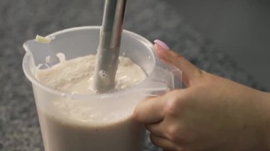 Genç aşçı kız tatlı yapıyor. Tatlı ve kek pişirir. Boşlukları doldurur ve meyveleri hazırlar. Pişirme, tatlı, tatlılar, karmaşık pişirme süreçleri.
