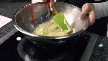 Genç aşçı kız tatlı yapıyor. Tatlı ve kek pişirir. Boşlukları doldurur ve meyveleri hazırlar. Pişirme, tatlı, tatlılar, karmaşık pişirme süreçleri.