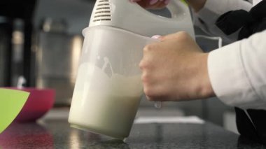 Genç aşçı kız tatlı yapıyor. Tatlı ve kek pişirir. Boşlukları doldurur ve meyveleri hazırlar. Pişirme, tatlı, tatlılar, karmaşık pişirme süreçleri.