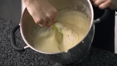 Genç aşçı kız tatlı yapıyor. Tatlı ve kek pişirir. Boşlukları doldurur ve meyveleri hazırlar. Pişirme, tatlı, tatlılar, karmaşık pişirme süreçleri.