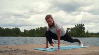 sports girl doing stretching near the river