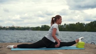 Spor kızı nehir kenarında geriniyor.