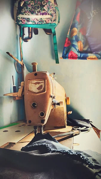 from one corner of the tailor\'s room, the sewing machine and some sewing items