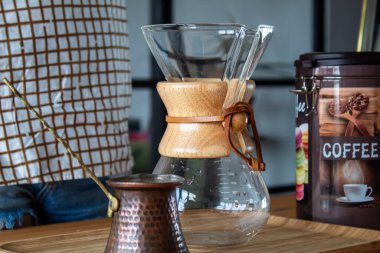 A woman preparing a bottle of coffee on a wooden desk. Reusable coffee filter. High quality photo