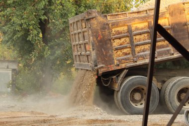 Eski sarı bir kamyon taş ve çakıl taşları düşürdü. Yüksek kalite fotoğraf