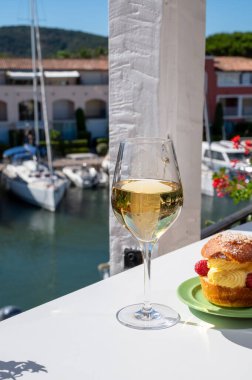 Tarte tropezienne ya da La Tarte de Saint-Tropez. Açık havada servis edilen kremalı ve taze meyveli çöreklerden oluşan tatlı tatlısı. Bir kadeh beyaz şarapla.