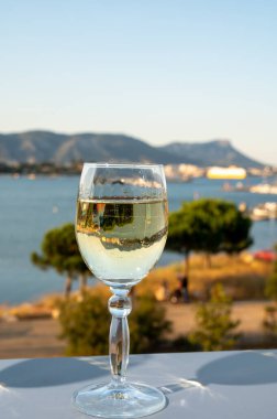 Fransız Rivierası 'nda yaz mevsimi, Cotes de Provence' den soğuk beyaz şarap içmek açık teraslarda Toulon, Var, Fransa limanı manzaralı.