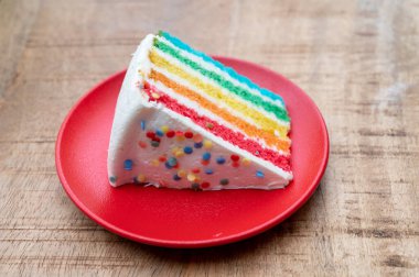 Bir parça taze fırınlanmış renkli doğum günü pastası.