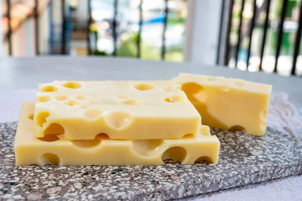 チーズコレクション 牛のミルクから作られた丸い穴を持つ半ハードフランスのチーズメンターを閉じます — ストック写真