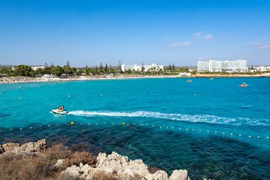 Kıbrıs Rum Kesimi 'nin Ayia Napa kentindeki beyaz kumlu Nissi plajında Akdeniz' in berrak mavi suyu
