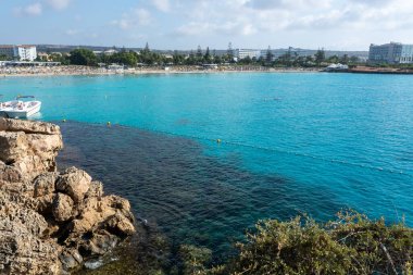 Kıbrıs Rum Kesimi 'nin Ayia Napa kentindeki beyaz kumlu Nissi plajında Akdeniz' in berrak mavi suyu