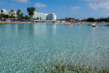 Kıbrıs Rum Kesimi 'nin Ayia Napa kentindeki beyaz kumlu Nissi plajında Akdeniz' in berrak mavi suyu