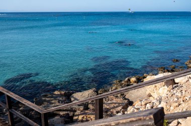 Kıbrıs Rum Kesimi 'nin Protaras kentindeki beyaz kumlu incir ağacı plajında Akdeniz' in berrak mavi suyu