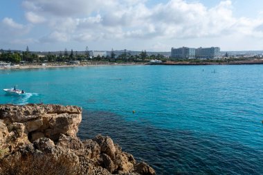 Kıbrıs Rum Kesimi 'nin Ayia Napa kentindeki beyaz kumlu Nissi plajında Akdeniz' in berrak mavi suyu