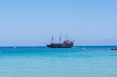Kıbrıs Rum Kesimi 'nin Protaras kentindeki beyaz kumlu incir ağacı plajında Akdeniz' in berrak mavi suyu