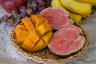 Kıbrıs 'ın egzotik meyveleri, taze olgun pembe guava, sarı sulu mango, muz ve yemeye hazır tatlı üzümler.