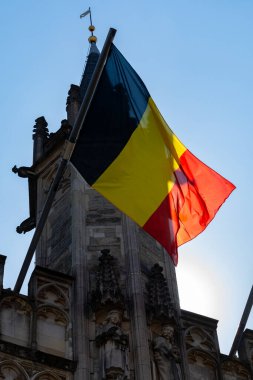 Güneşli bir günde Belçika 'nın siyah, sarı, kırmızı, ulusal cephesi belediye kulesinde feragat ediyor.
