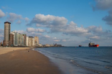 Rıhtım, kum tepeleri ve Vlissingen şehri, güneşli günbatımında kumlu plaj, Zeeland, Hollanda