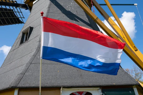 Hollanda bayrağı ve arka planda tahıl öğütmek için kullanılan eski geleneksel yel değirmeni