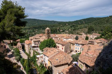 Fransa 'nın Provence kentindeki Moustiers-Sainte-Marie kasabasındaki dağlık uçurum, eski evler, yeşil vadi. Turistik bir yer.