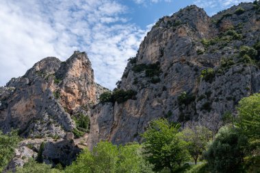 Fransa 'nın Provence kentindeki Moustiers-Sainte-Marie kasabasındaki dağlık uçurum, eski evler, yeşil vadi. Turistik bir yer.