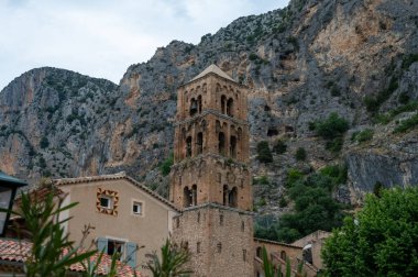 Fransa 'nın Provence kentindeki Moustiers-Sainte-Marie kasabasındaki dağlık uçurum, eski evler, yeşil vadi. Turistik bir yer.